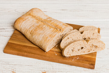 Assortment of freshly sliced baked bread with napkin on rustic table top view. Healthy unleavened bread. French bread slice
