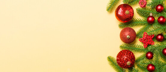 Christmas composition made of fir tree, balls and different decorations on colorful background. Top view of New Year Advent concept with empty space for your design