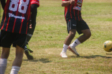 Obraz premium blurry image of amateur soccer players in action outdoor match