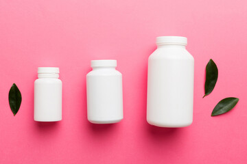 supplement pills with medicine bottle health care and medical top view. Vitamin tablets. Top view mockup bottle for pills and vitamins with green leaves, natural organic bio supplement, copy space