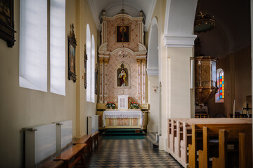 A side chapel in a church featuring a statue of Jesus, marble altar, ornate details, stained glass,...