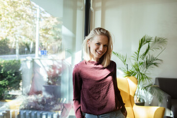 Smiling woman in bright modern office with natural light
