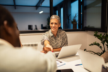 Team collaboration in modern office space with diverse professionals using laptops and discussing...