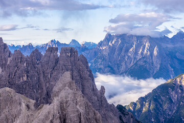 Fototapeta premium Dolomites mountains nasty weather in autumn with dark cloudy sky before the storm. Black clouds on the sky above the mountain rocky summits and peaks, stormy weather in the Dolomiti Alps, Italy