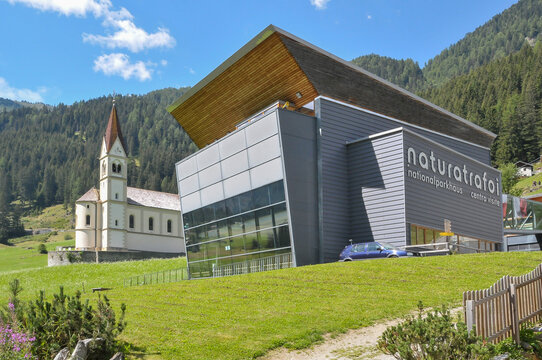 Vista de un moderno centro de visitantes y la iglesia de la Visitaci&oacute;n en el pueblo alpino de Trafoi en el Tirol del Sur, un d&iacute;a soleado