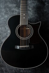 Fototapeta premium Elegant Black Acoustic Guitar on Dark Background | Perfect for Music, Concerts, and Artistic Photography | High-Quality Stock Image