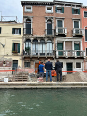 Renovation Work on Historic Venetian Building by a Canal
Workers restoring a historic Venetian...