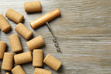 Wine corks with corkscrew on wooden background 