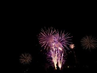 Vibrant fireworks lighting up the black sky in celebration of the new year, celebration, party, glowing