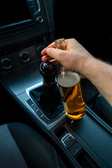 Man with a bottle of beer in the car. Drunk driving concept.