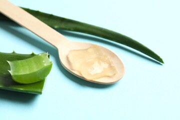 Green aloe vera with spoon on color background