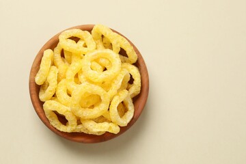 Corn ring crisps on color background, top view