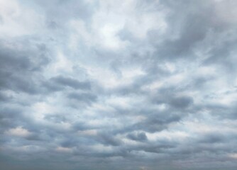 the grey overcast sky. A sweeping pattern of clouds evolving as an intricate background pattern. Cloudscape scenery, overcast weather.