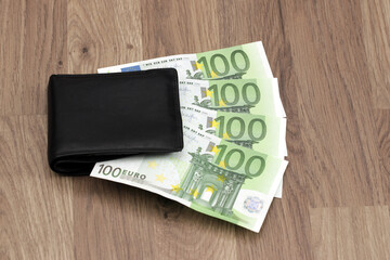 400 euros sticking out of the wallet. Four paper banknotes of 100 euros each. Symbol for growing expenses, inflation, paying household bills, salary, bonus, winnings, lottery.