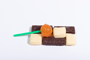 Creamy chocolate and orange lollipops on a white background