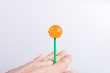 With orange lollipops in your hands