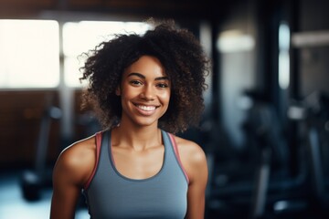 Fototapeta premium Smiling portrait of a young African American female fitness trainer in gym