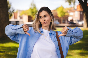 Young blonde short hair woman wearing blue shirt and white top looking unhappy and angry showing...