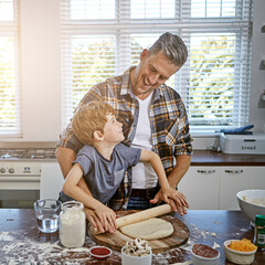 Father, child and cooking help in kitchen for teaching with pizza, toppings and instructions for dinner. Family, man and son with preparation in home with salami, mushrooms and rolling pin for dough