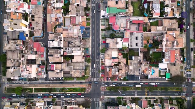 Vista desde arriba de una ciudad sudamericana en una tarde serena, donde las calles est&aacute;n ocupadas por un tr&aacute;fico ligero y las casas muestran signos de envejecimiento
