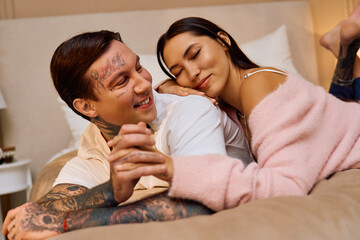 Loving partners relax together on a soft bed, embracing each other with joy and affection.