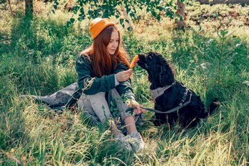 red-haired woman, dog in park with ice cream, Nature, Pets, and Popsicles: The Perfect Summer Trio