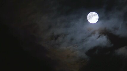 full moon shines brightly through the clouds in the night sky, on the right side