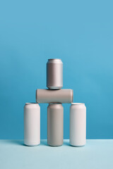 Three stylish, minimalistic aluminum cans, set against blue background in creative composition. Mockup for beer, soda drinks advertisement. Ideal for branding and product placement. Copy space