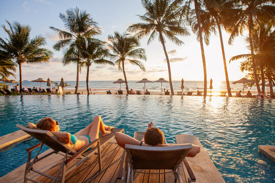 couple on holidays, beach vacation in luxury hotel near swimming pool at sunset