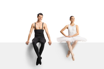 Naklejka premium Full length shot of a male and female ballet dancers sitting on a blank panel