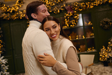 Fototapeta premium Young lovers joyfully celebrate together amid twinkling lights and holiday cheer.
