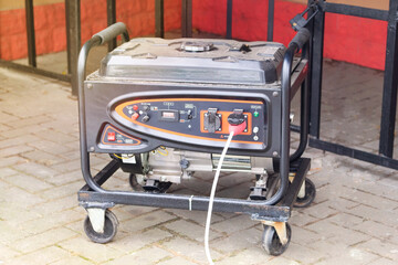 Portable gasoline or diesel generator to provide electricity. Problem with electricity. Blackout. Sunny.