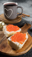 Sandwiches with red caviar and a cup of tea, a cozy breakfast.
