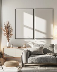 A cozy living room with a white sofa. a wooden side table. a lamp. a vase with dried flowers. and two empty picture frames