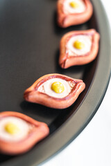A close-up view of khachapuri magnets arranged on a black tray, highlighting the vibrant colors and artistic design of this Georgian culinary icon
