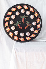 A vibrant and playful combination of khachapuri, khinkali, and palm tree magnets arranged on a black tray, bringing a touch of culture and creativity to your kitchen