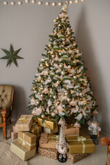 A tall Christmas tree adorned with rustic-style ornaments, including small felt trees and cotton balls, creates a warm and inviting atmosphere. The tree is surrounded by a pile of wrapped presents.