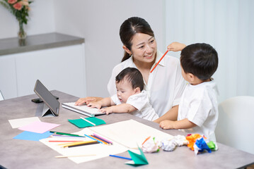 リモート中の母親の横で遊ぶ子供