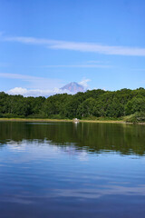 Koryak volcano. A serene view of a majestic mountain mirrored in tranquil lake waters, surrounded...