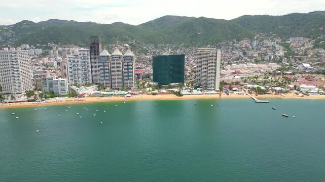 Panoramic side view from above Icacos Beach, capturing the beachfront hotels and sweeping coastline of Acapulco