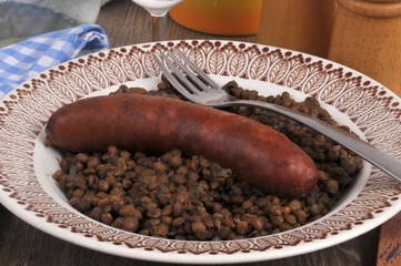 Assiette de saucisse et lentilles servie avec une fourchette en gros plan