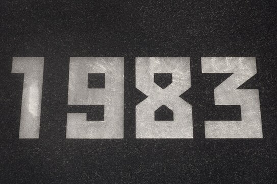Black granite slab with white numbers 1983 on it
