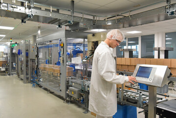 medical products manufacturing in a modern factory - worker operates modern industrial plant