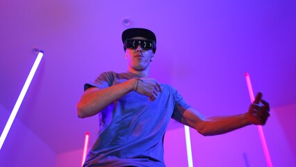 Low angle camera of caucasian dancer wearing fancy glasses and performing break dancing. Attractive man shown energetic performance and movement while looking at camera with confident. Regalement.