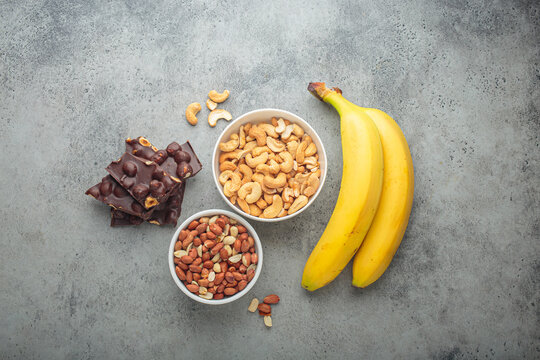 Assortment of food rich in a magnesium: cashews, peanuts, bananas, and chocolate hazelnuts, a healthy snack for mood and brain boost