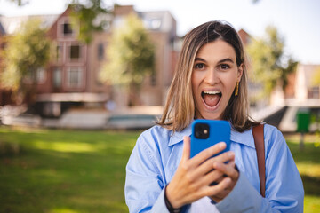 Blonde short hair woman browsing internet with cellphone mobile phone wearing casual clothes shirt...