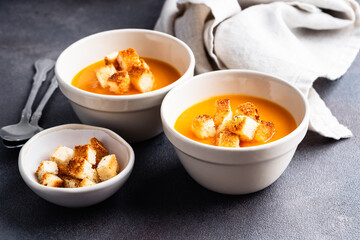 Butternut squash soup with bread croutons in  ceramic bowl