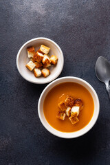 Butternut squash soup with bread croutons in  ceramic bowl
