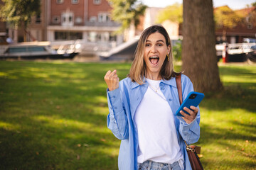 Blonde short hair woman browsing internet with cellphone mobile phone wearing casual clothes shirt...