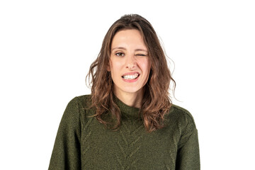 A woman in a green knit sweater smirking and with one eye squinted against a white background